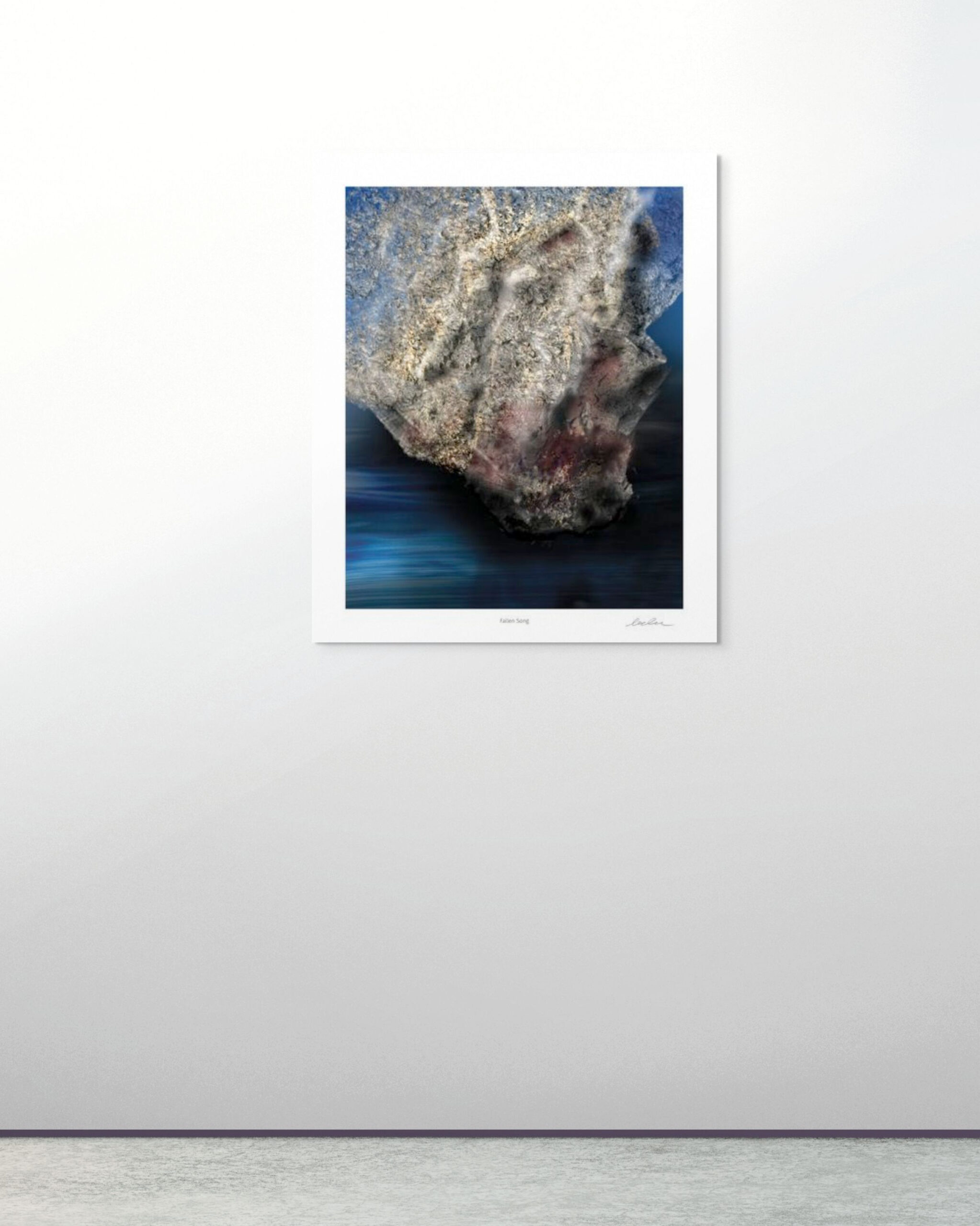 Interior mockup showing the artwork Fallen Song mounted on a light grey gallery wall. The print appears without a frame, highlighting the stone-like abstract form suspended above deep blue tones. The minimalist setting provides scale and context for the artwork.
